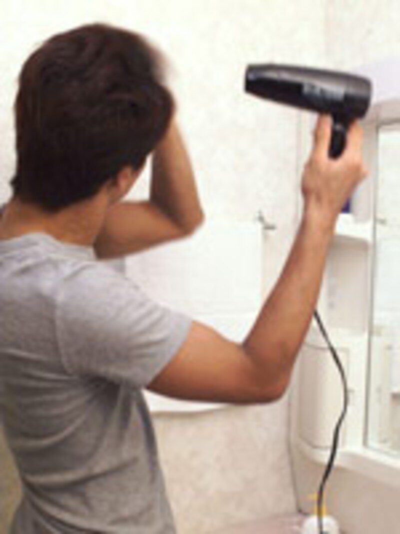 ドライヤーをかける男性