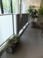 半分はすりガラスに、半分はルーバーにして採光や通風に配慮しながらプライバシーを守る手摺の例
