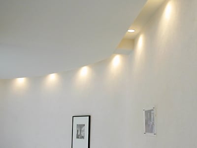 壁際の天井にダウンライトを埋め込み壁面をライトアップしているモデルハウス(三菱地所ホーム)