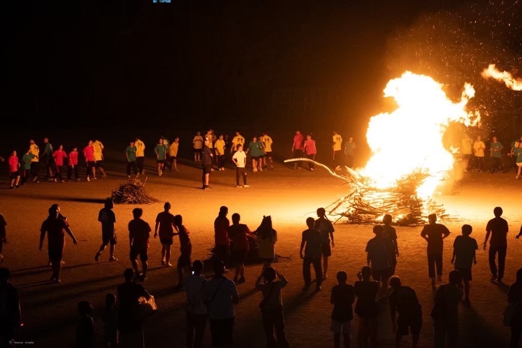 学園祭のフィナーレに実施される伝統行事「火の集い」。燃え上がる炎を生徒たちが静かに囲み、幻想的な空気に包まれる。
