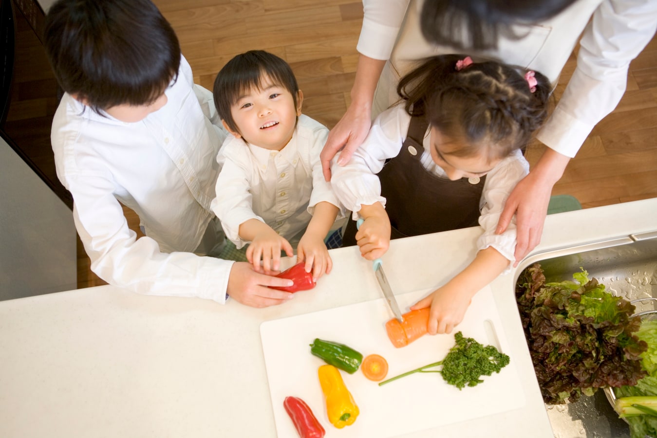 可爱的小女孩在厨房切胡萝卜。帮助孩子做家务的概念照片摄影图片_ID:337566576-Veer图库