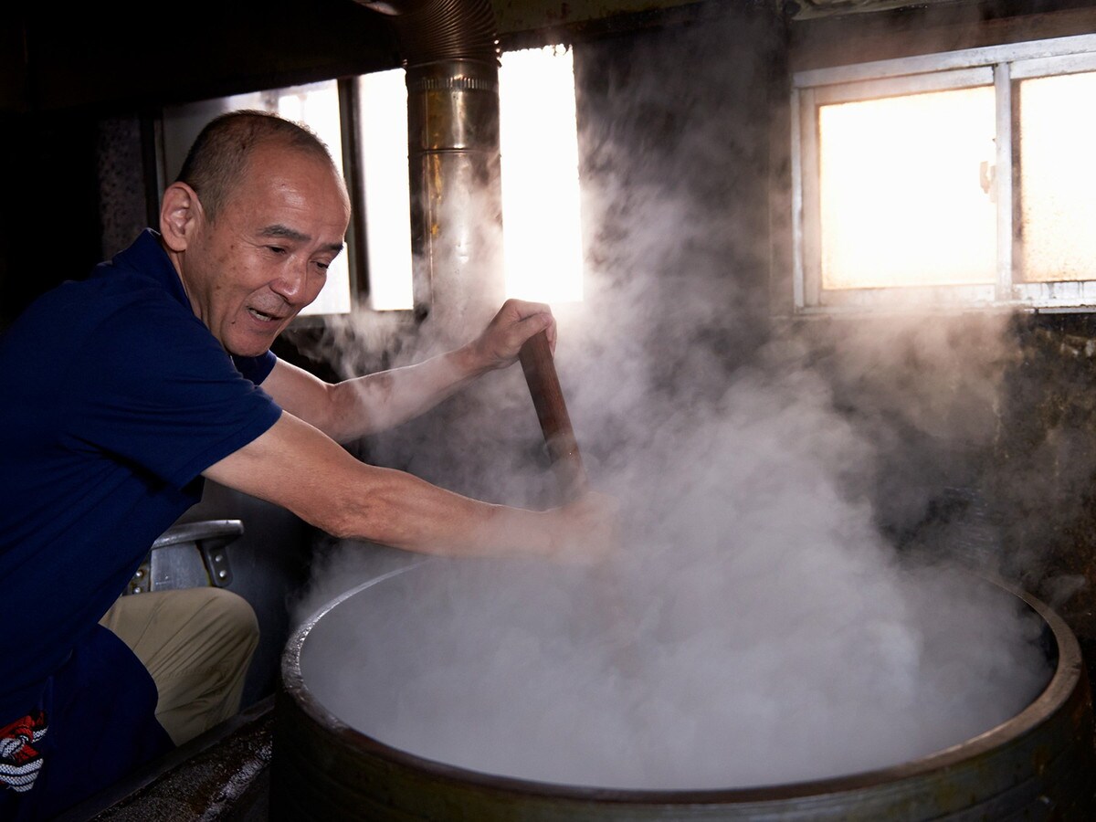 「築炉釜」で命ともいえるスープを炊き上げる城戸さん（現在は引退）