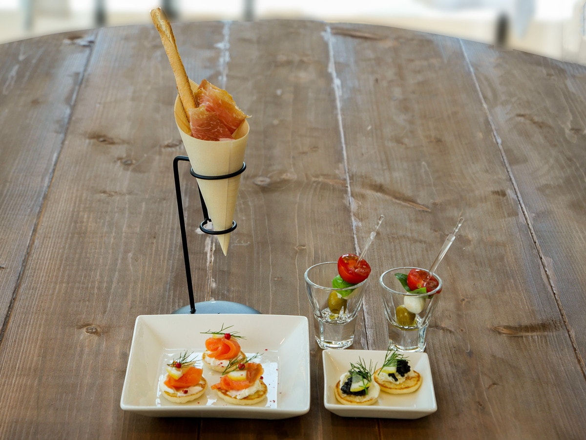 一口サイズのおつまみ“ピンチョス”。左から時計回りに、スモークサーモンとクリームチーズのブリニ（3個700円）、キャビアとクリームチーズのブリニ（2個900円）、カプレーゼ（2個500円）、生ハム（800円）