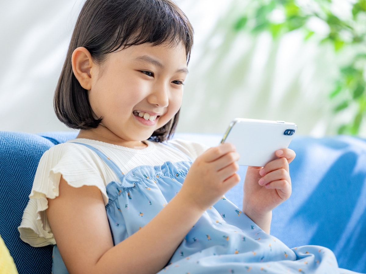 スマホを持ち、嬉しそうにする子ども