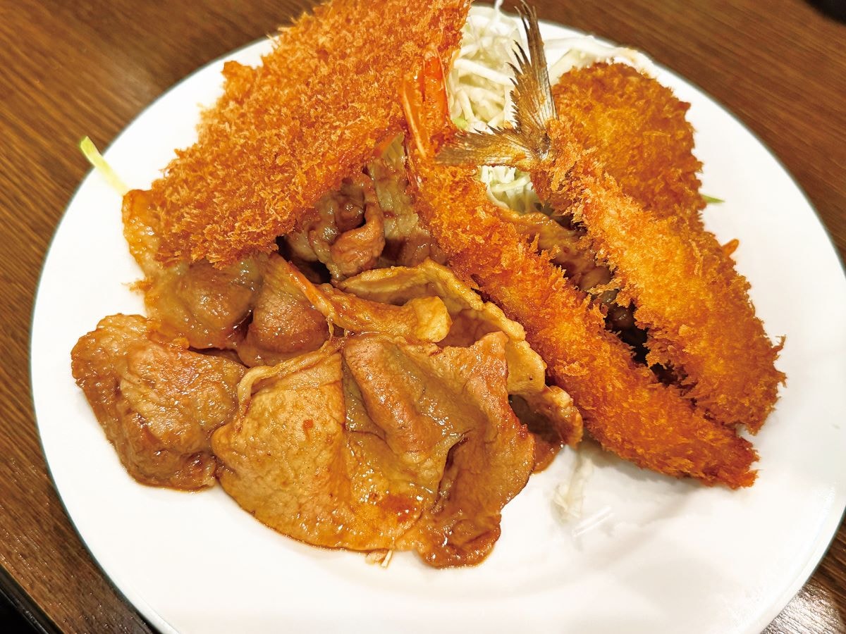 人気の3種定食の一つ。写真は、豚しょうが焼・アジ・エビフライのミックス「B定食」に、ハムカツを追加した一皿