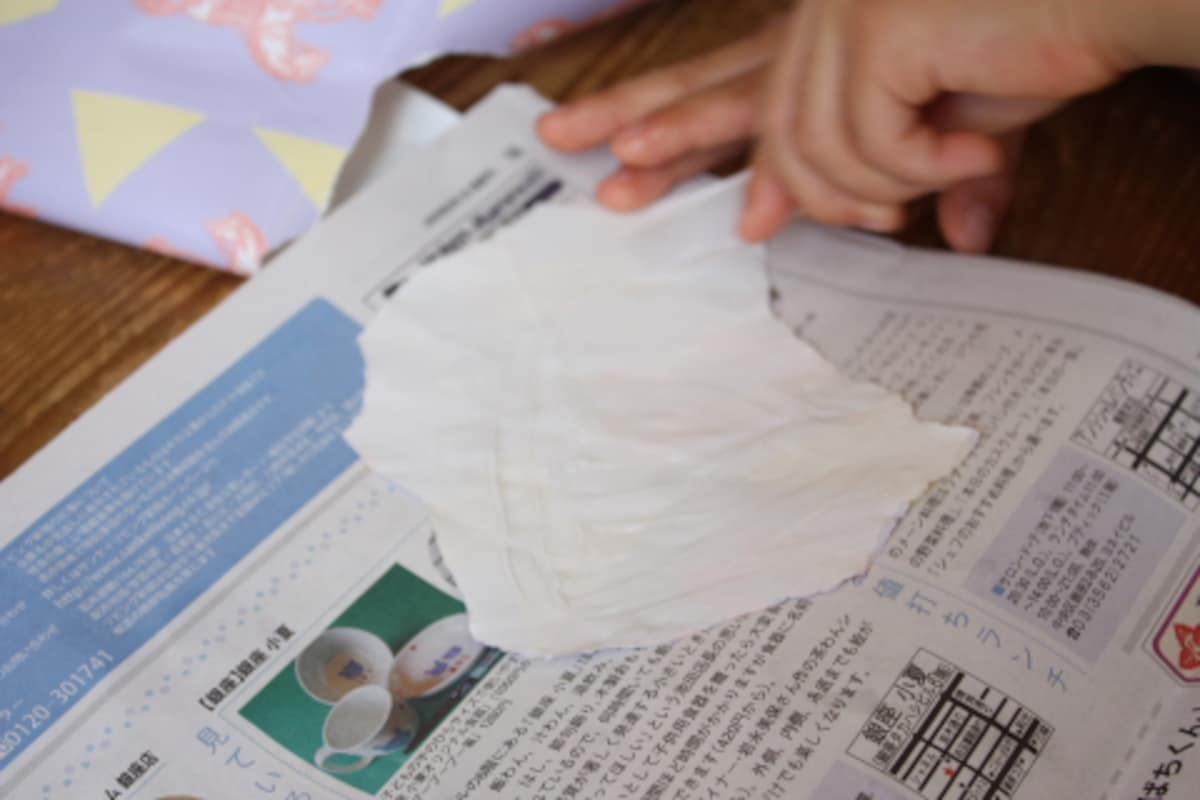包装紙を好きな形に指で小さく破り、裏にのりをつけます。新聞紙を敷いてのりを塗ると床や机の汚れ防止になります。