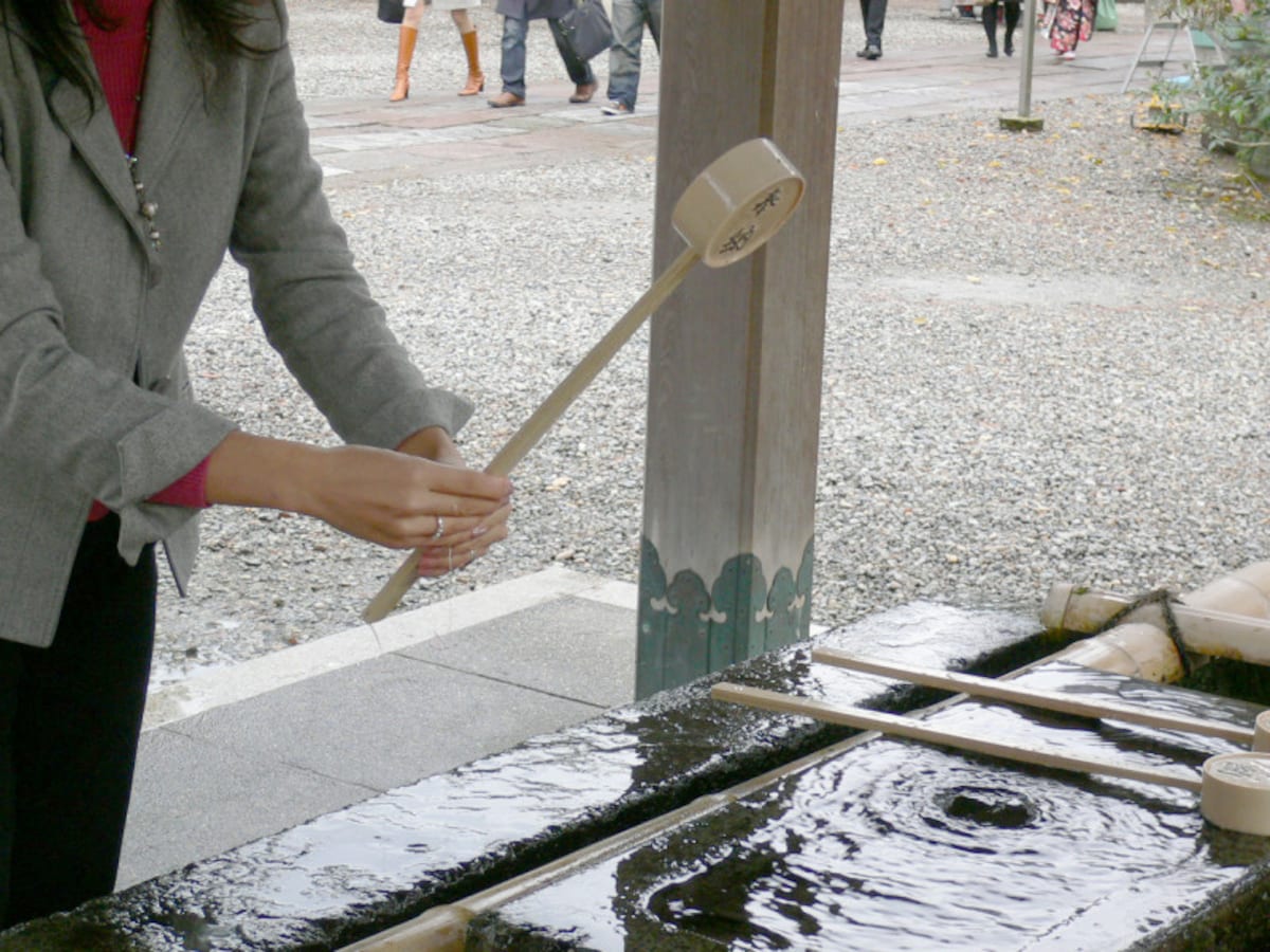 手水のやり方・手水舎での作法5：最後に、両手で柄杓を立てて柄杓の柄に水を流す