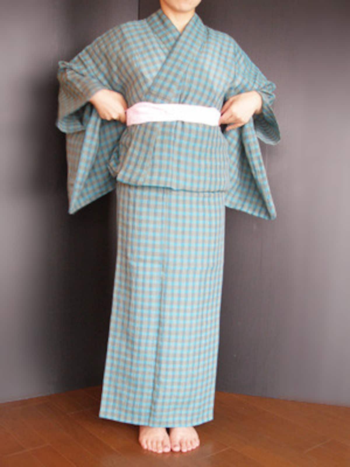 浴衣着付け20：1回結んでから、ねじって交差させ、両脇にはさみこみます