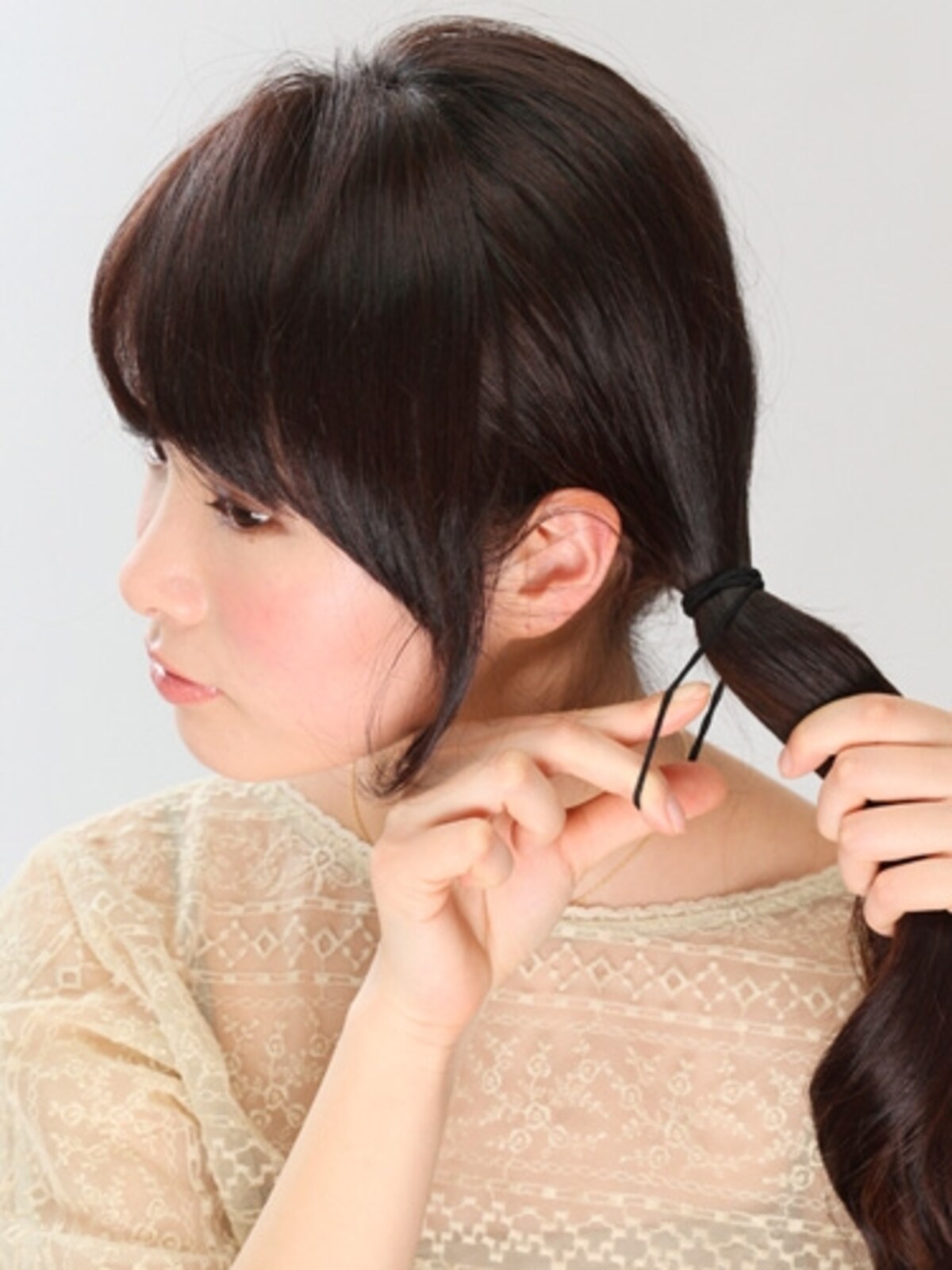 1顔周りの髪を少し残して、髪を片サイドにまとめてゴムでひとつに結ぶ。