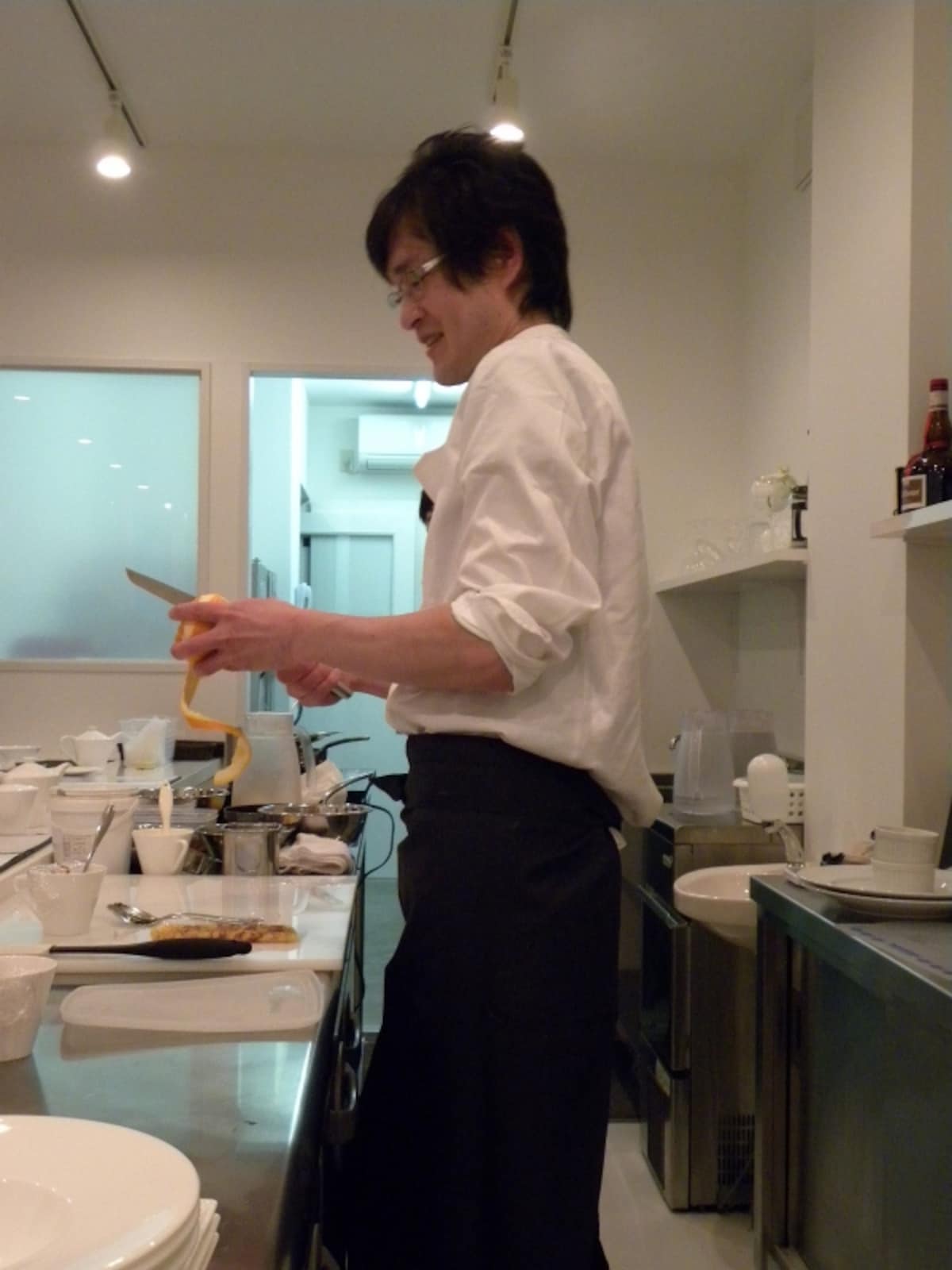 クレープシュゼット用に、柑橘の皮を長く剥く吉岡シェフ