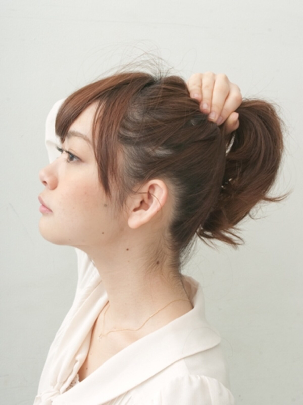 あごを上げながらまとめると、えりあしのたるみがなく仕上がる