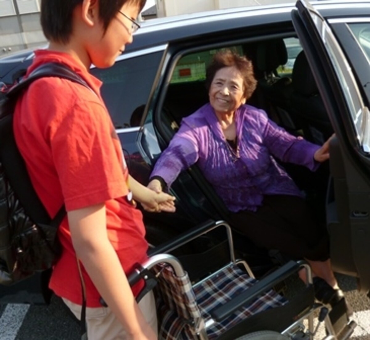 孫が手を差し伸べて車いすに