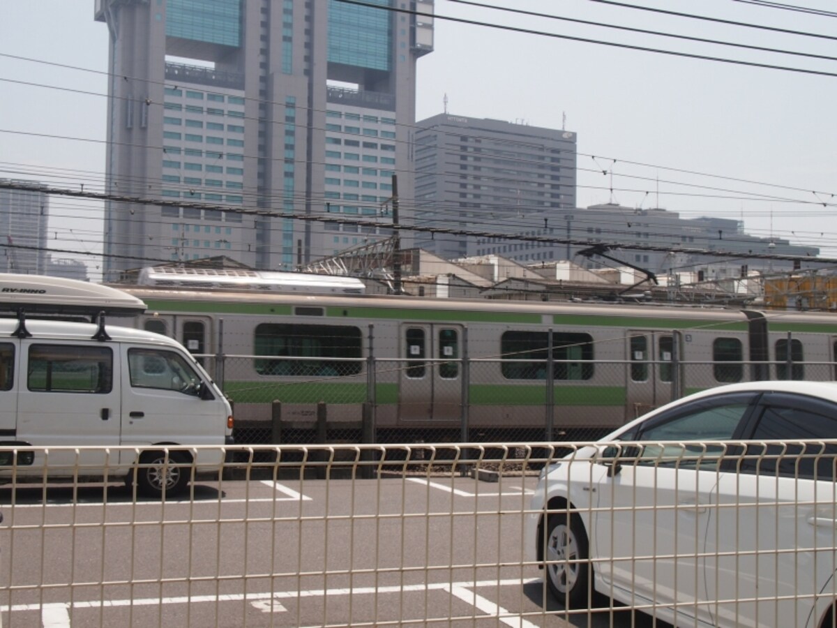 建物の間や駐車場から山手線が見える