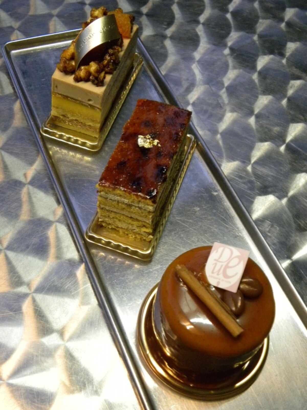 高山シェフの試作品。手前:シナモンとコーヒー風味のチョコレートムースのケーキ、中央:キャラメル味の生地とコーヒーのバタークリームのケーキ、奥:アプリコットとくるみ、アールグレイ風味のミルクチョコムース
