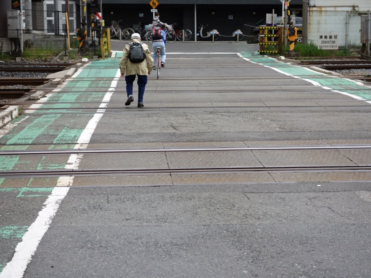 踏切を渡る高齢者