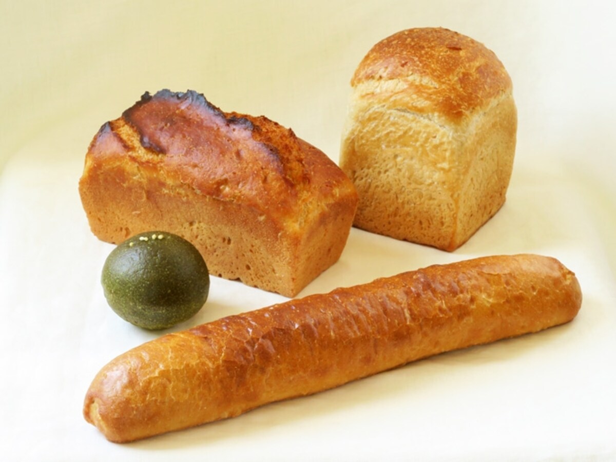  手前から時計回りに、有機栽培ホクシンのクープのないバゲット（200円）、有機抹茶の粒あんぱん（190円）、米味噌と米油のパン（700円、ハーフ350円）、有機栽培ホクシンと米油の食パン（380円）（2015年7月15日撮影）