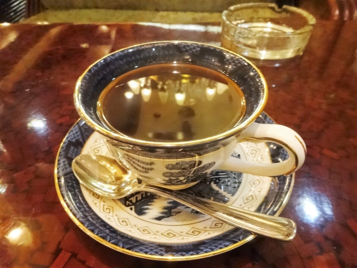 天井のシャンデリアはコーヒーに映りこんでいる