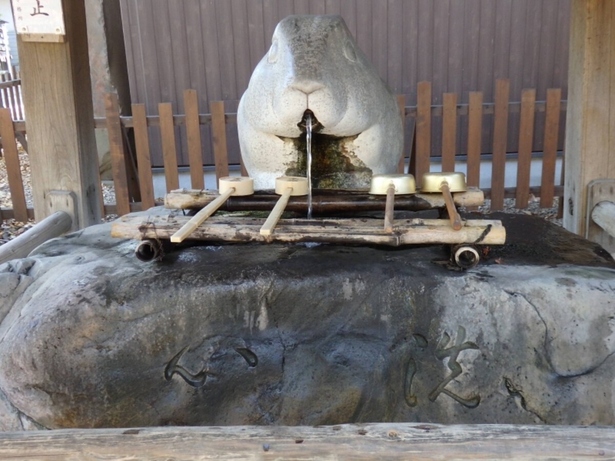口から水を吐き出す手水舎のウサギ