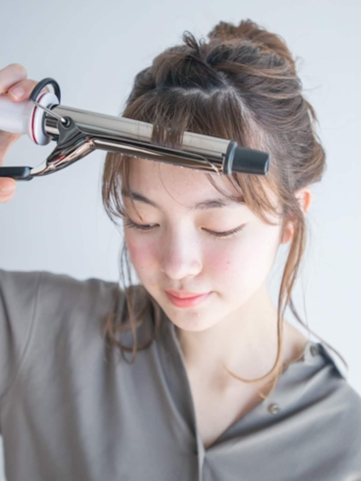細めのアイロンで前髪を巻く