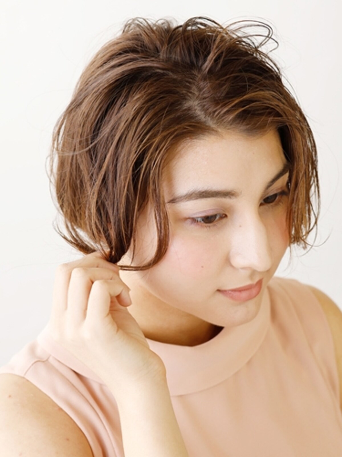 顔まわりの髪を巻き、ほぐしながら毛束を作る