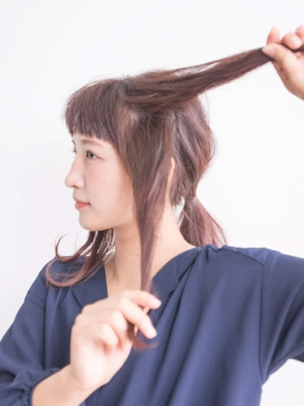 両手を使って髪の毛を取る