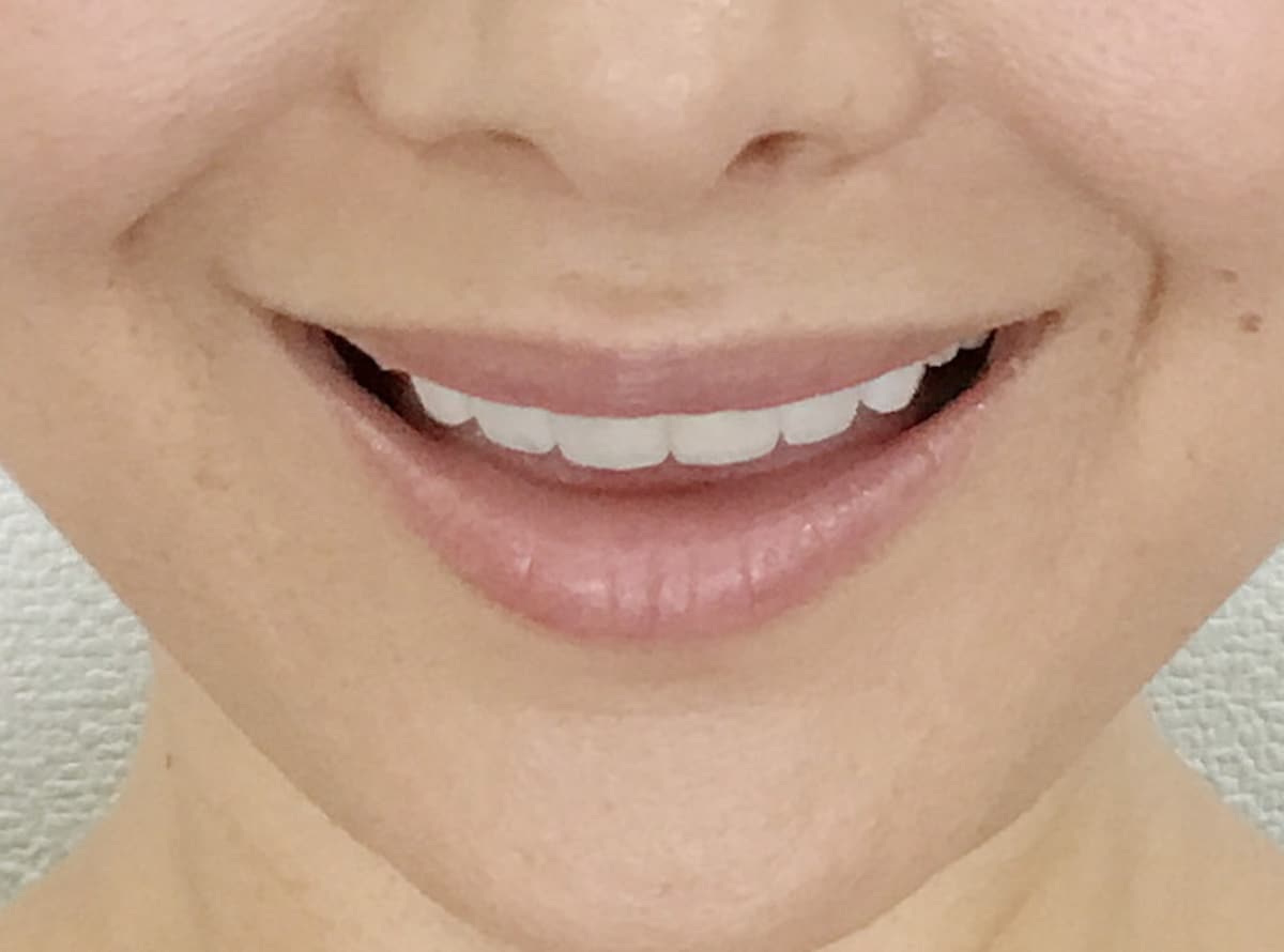口を少し開けて笑う