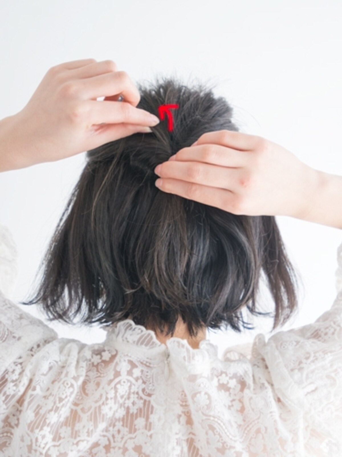 ゴムを押さえて結び目の表面の毛を引き出す