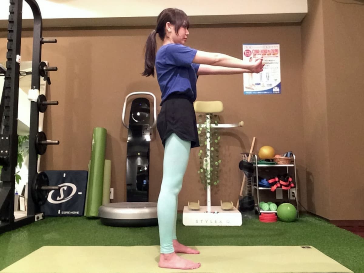 動作1. 足を肩幅に開き、両手を前に伸ばします。