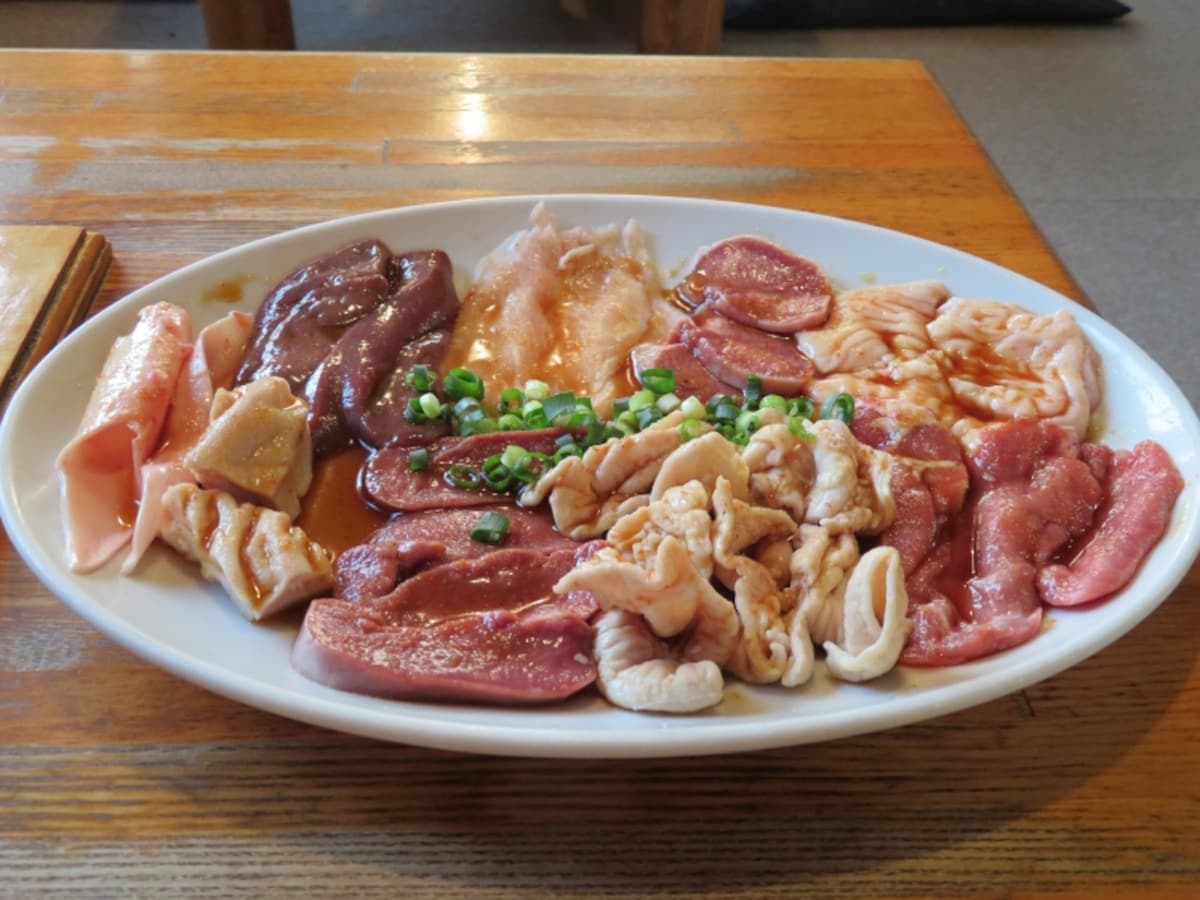 左端のタケノコを含み9種類の食材が一皿に盛られた「初めてのホルモンセット」