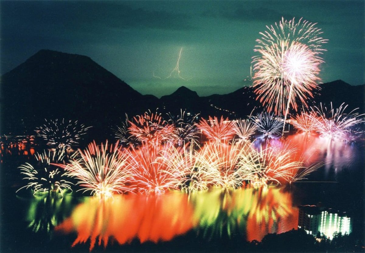 湖の上に咲く色とりどりの花火 