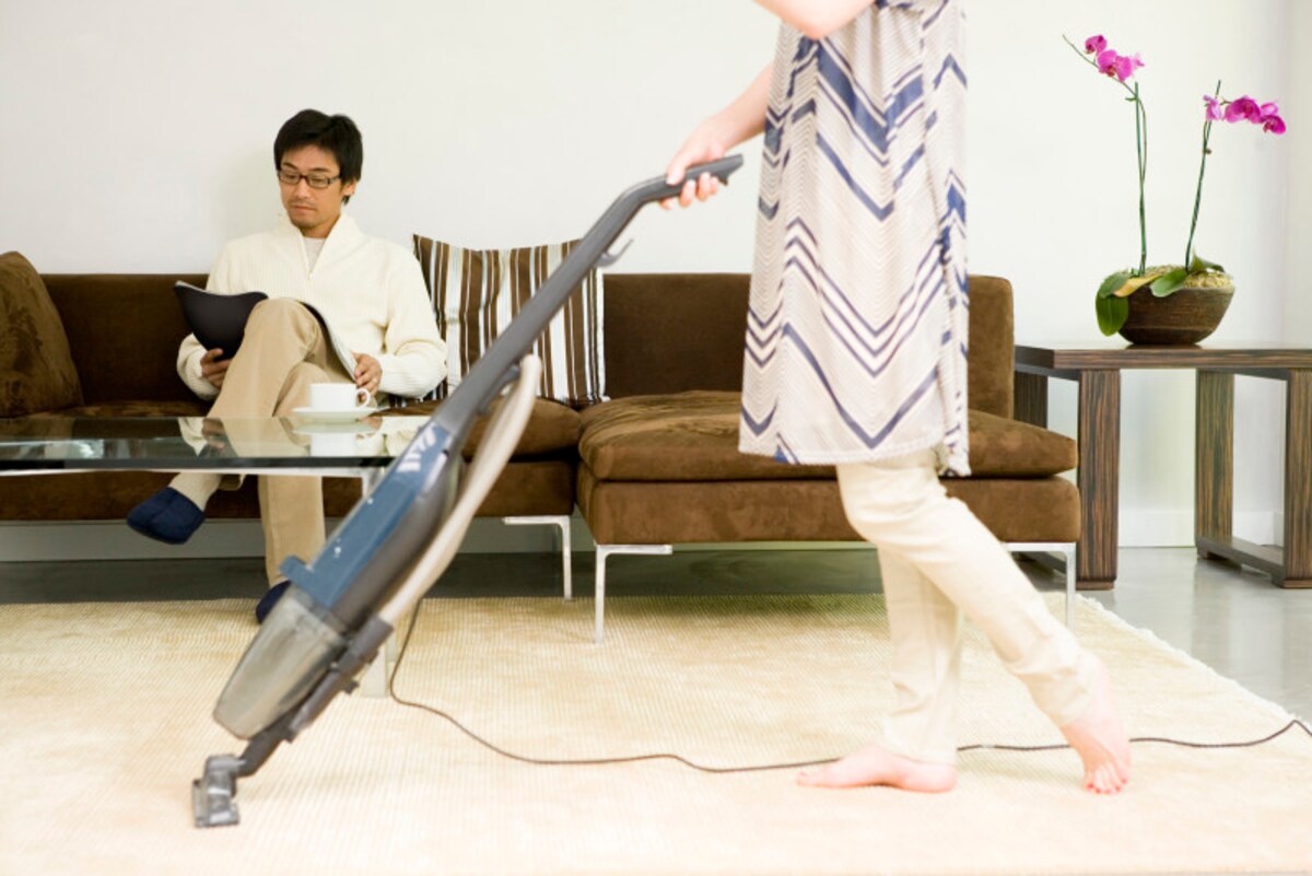 家事をする妻、くつろぐ夫