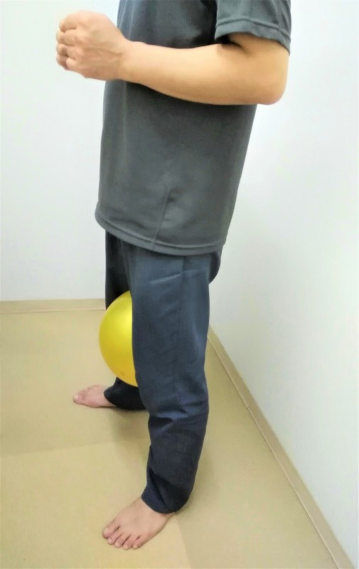 1　両脚の間に柔らかめのボールかクッションを挟み立ちます