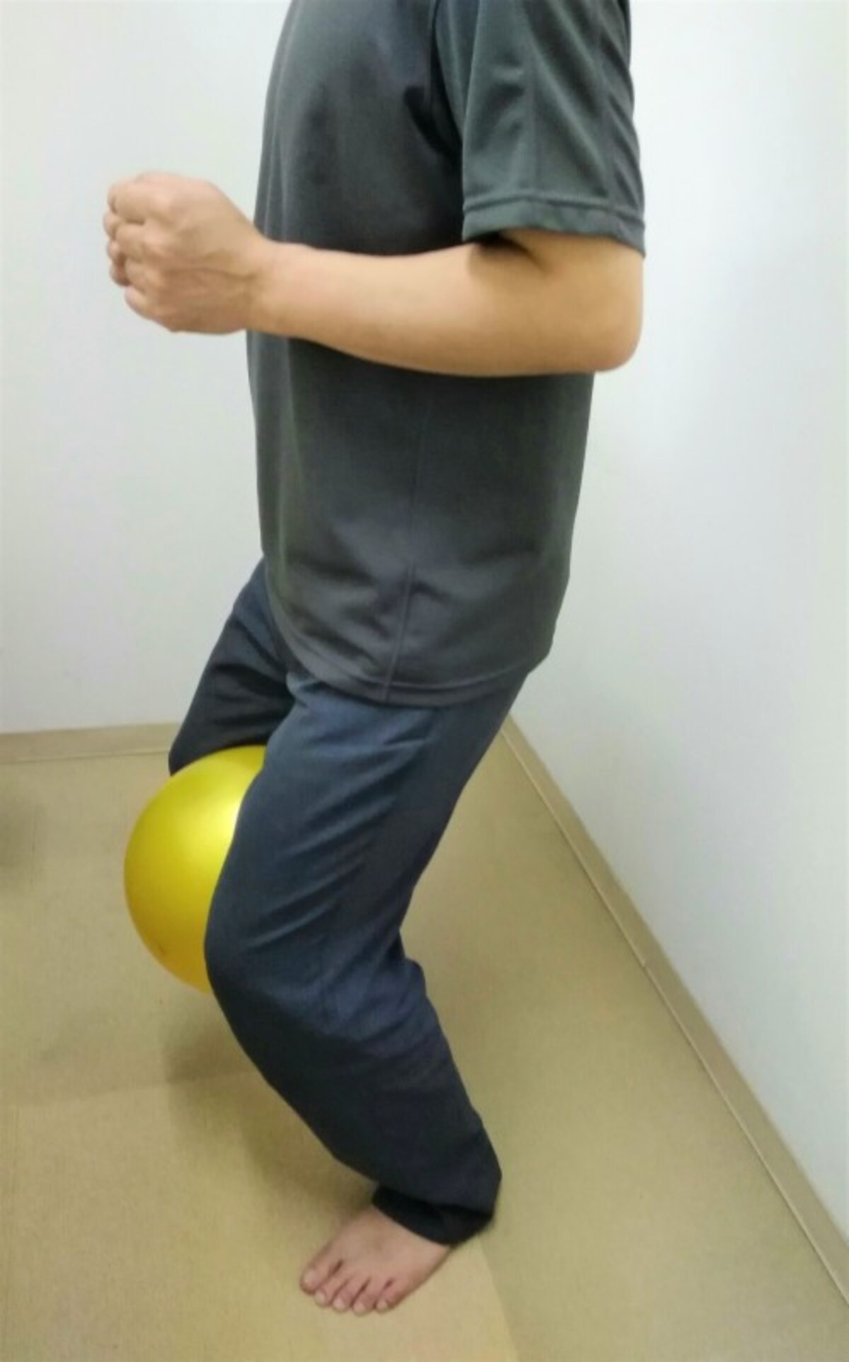 2　体は正面に向け、お尻を少し後方へ引く意識を持ち脚の付け根から股関節と膝を曲げていきます。軽い負荷にするため５つ数えながら股関節と膝を曲げ、ゆっくりと元の姿勢に戻します