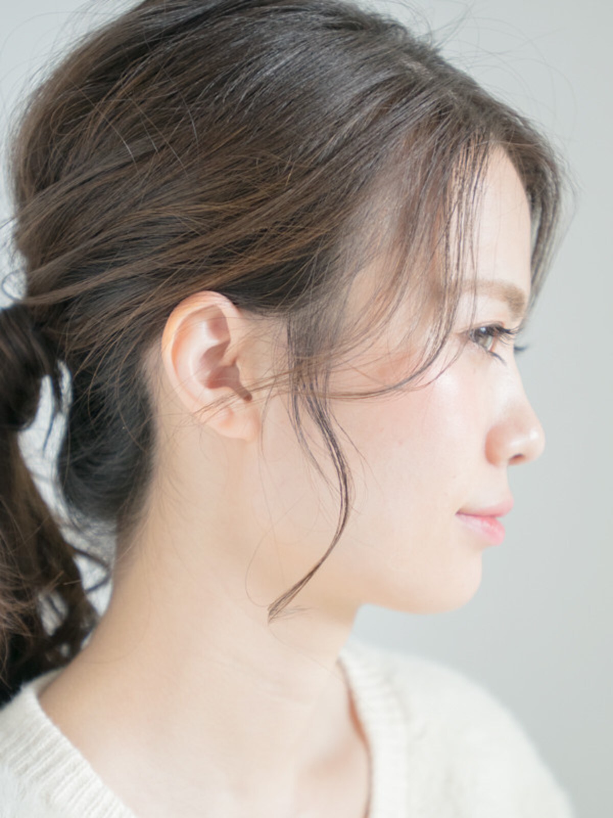 耳前の毛を少量わけとり、根元からオイルやクリームワックスをつけ細い束にする