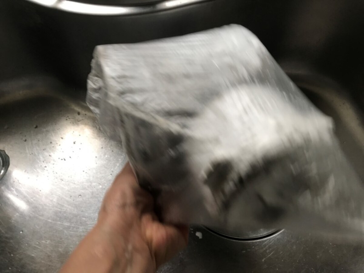 重曹を１～２カップ振りかけたら、袋を膨らませて口を閉じ、開かないようしっかり持って、振りながら全体に重曹をまぶす。
