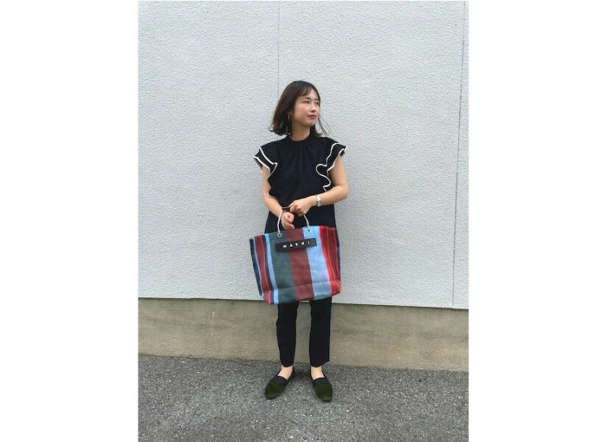 黒ベースに白いパイピングが映えるフリルブラウスが華やか　出典：WEAR
