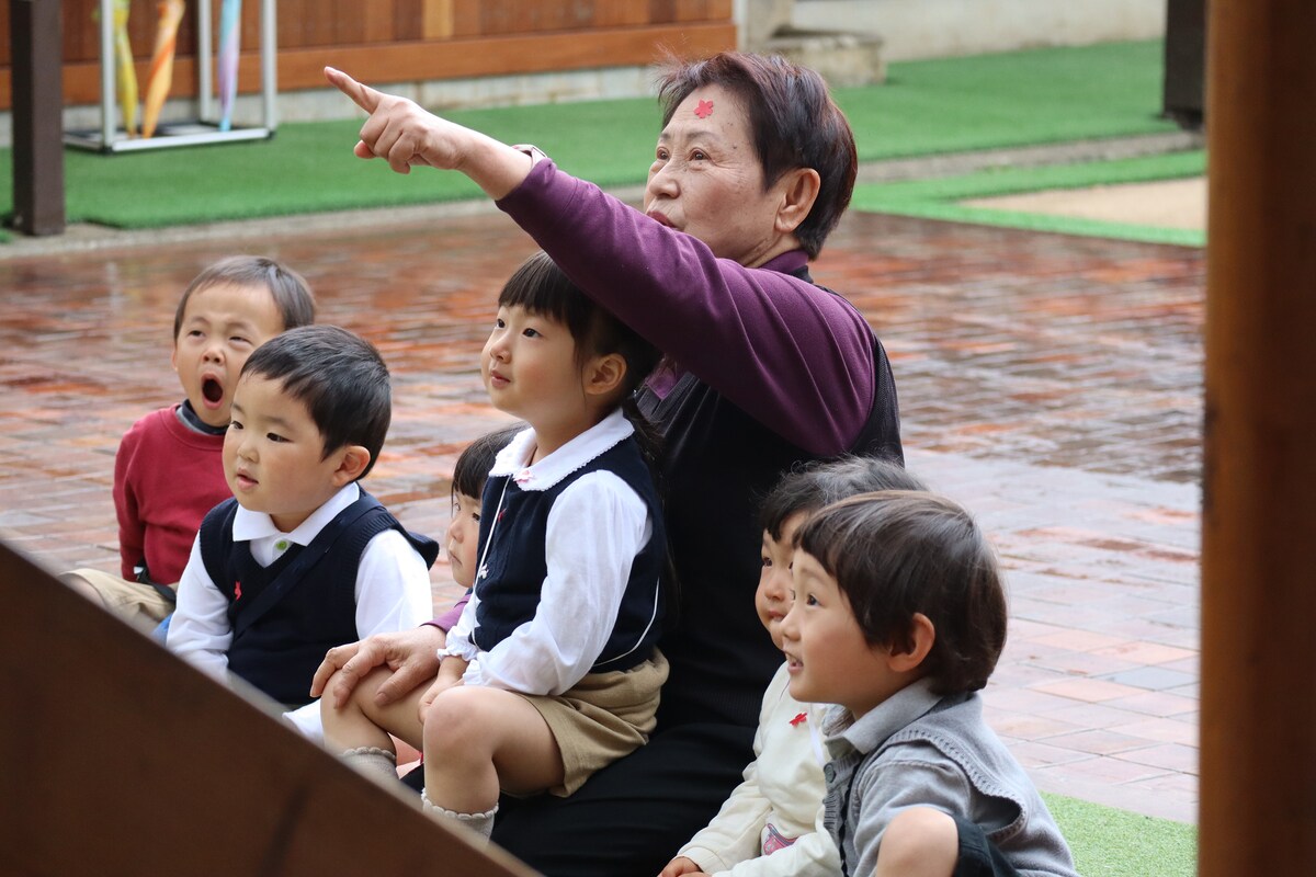 天野優子園長と園児たち。©️風の谷幼稚園