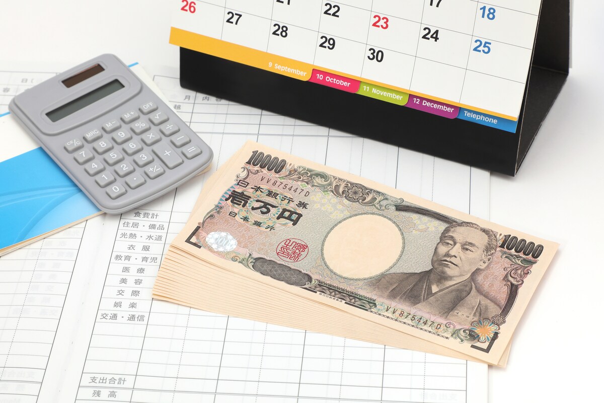 一万円札とカレンダーと電卓