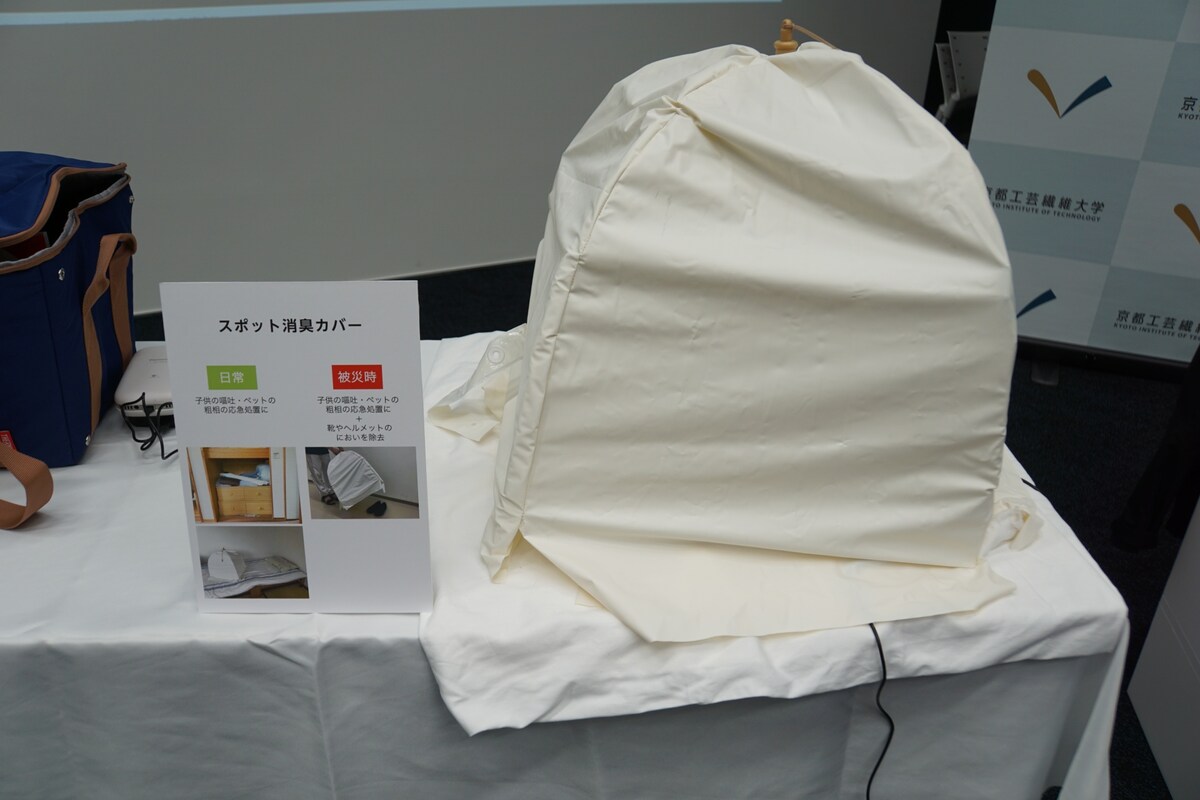 食事をハエなどの虫から守る「蠅帳（はいちょう）」にナノイーX発生器を入れて使う「スポット消臭カバー」。「開いた状態で中にナノイーX発生器を入れることで、下の空間を消臭できます。日常においては、子どもやペットがもどしてしまった時、応急処置的に拭き取った後に使うとか、なかなか洗えない布団やソファーなどの匂いを取るために使えます。ソールが汚れていて靴箱にしまいたくないスポーツシューズなどを、玄関の土間に置いたまま被せるという使い方を想定しています」（畔柳助教）