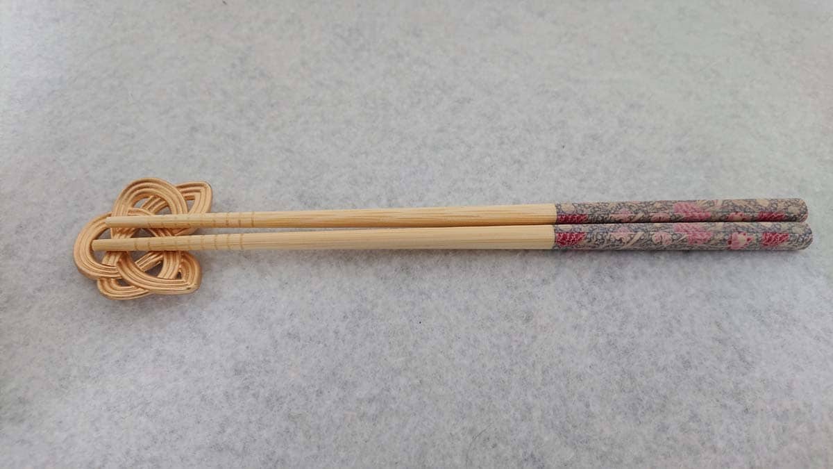 セリアの「箸置き 水引きデザイン結び」に「竹製箸 2P 21cm ウィリアムモリス柄」を置く