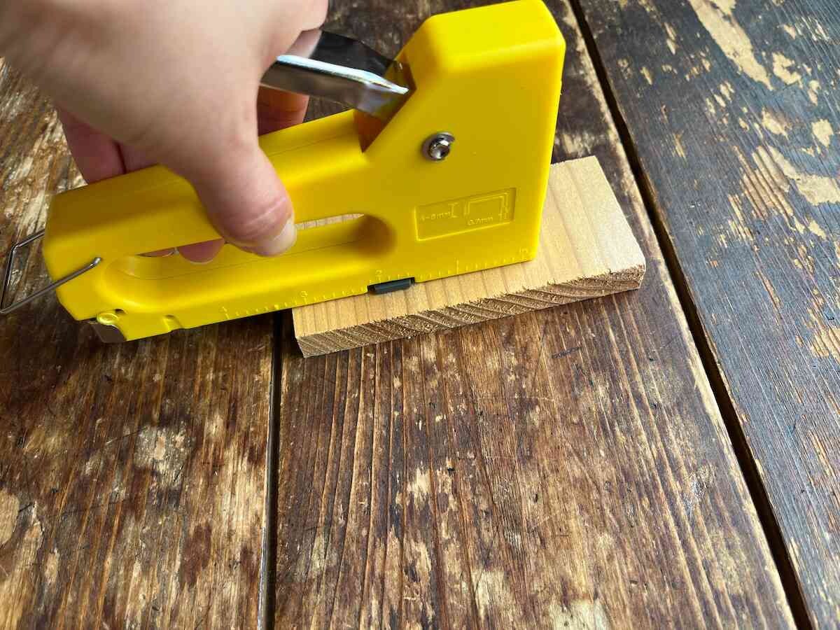 グリップとハンドルを持って、針を打ち込むものに射出口が垂直になるように押し当てる
