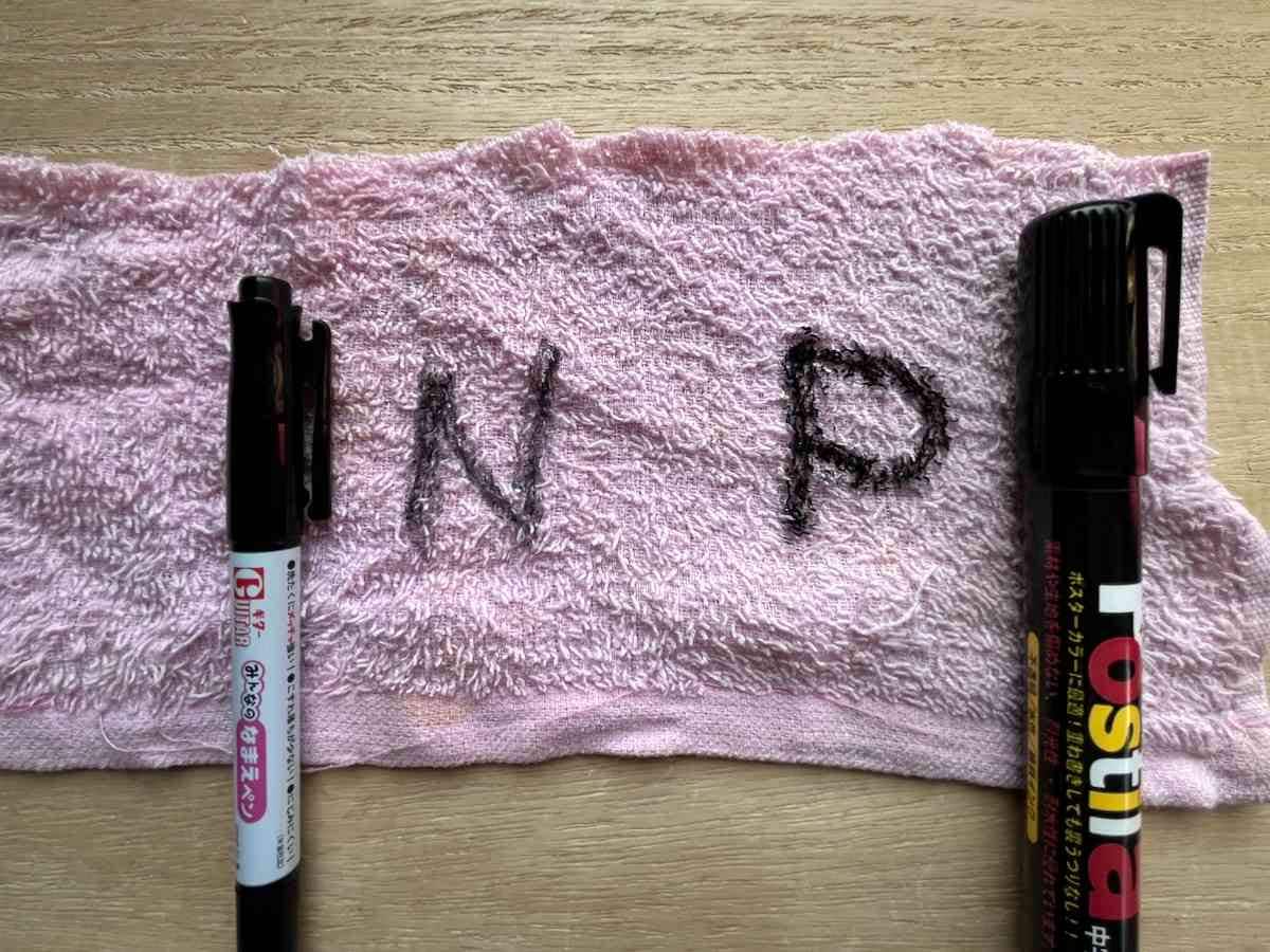 ダイソーの布用染色ペン「みんなのなまえペン」（左）、「62 セーラーポスティラ 黒」（右）