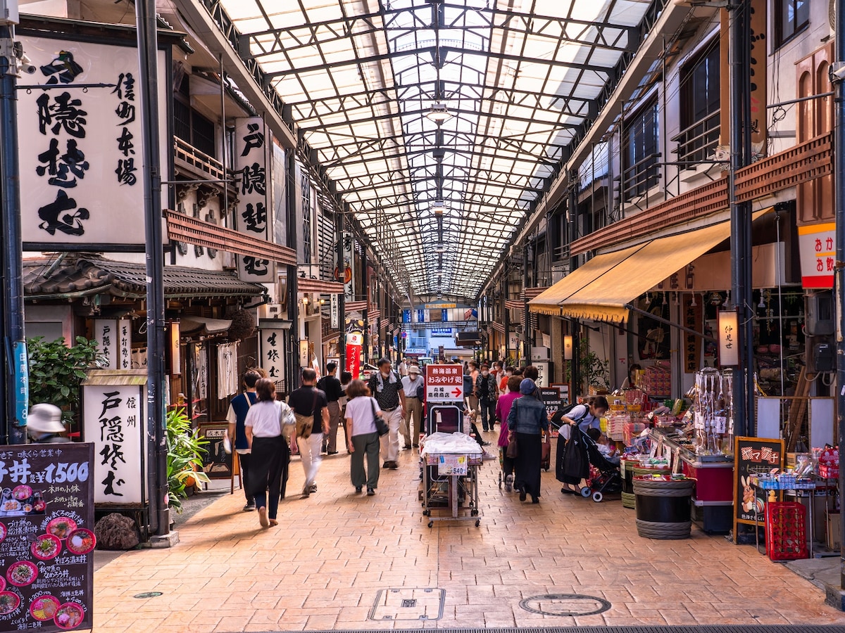 飲食店や土産物店、スイーツ店などが立ち並ぶ熱海駅前の商店街（画像：PIXTA）