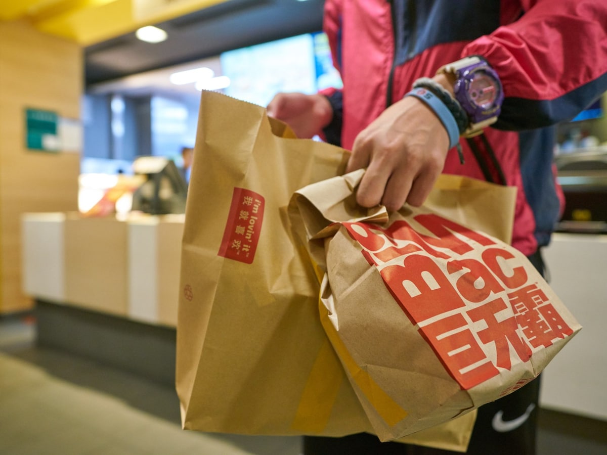 マクドナルドの紙袋を持つ男性（サムネイル画像：Shutterstock）