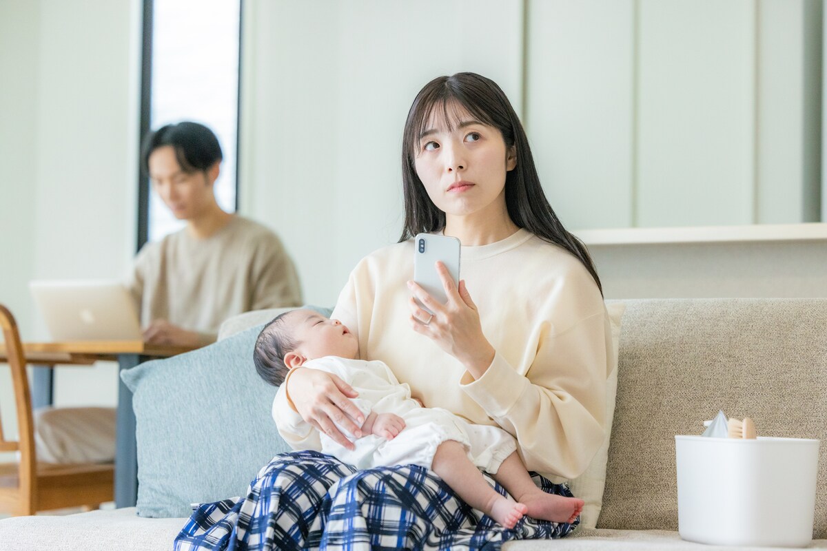 ソファで赤ちゃんを抱く女性