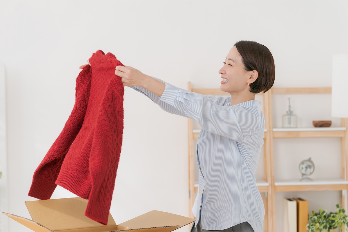 箱からセーターを取り出す女性