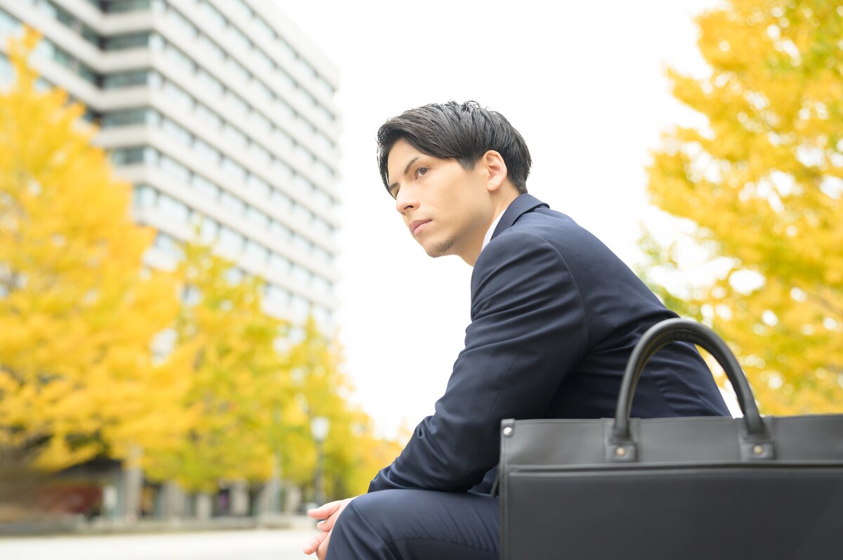オフィス街のベンチに座る男性