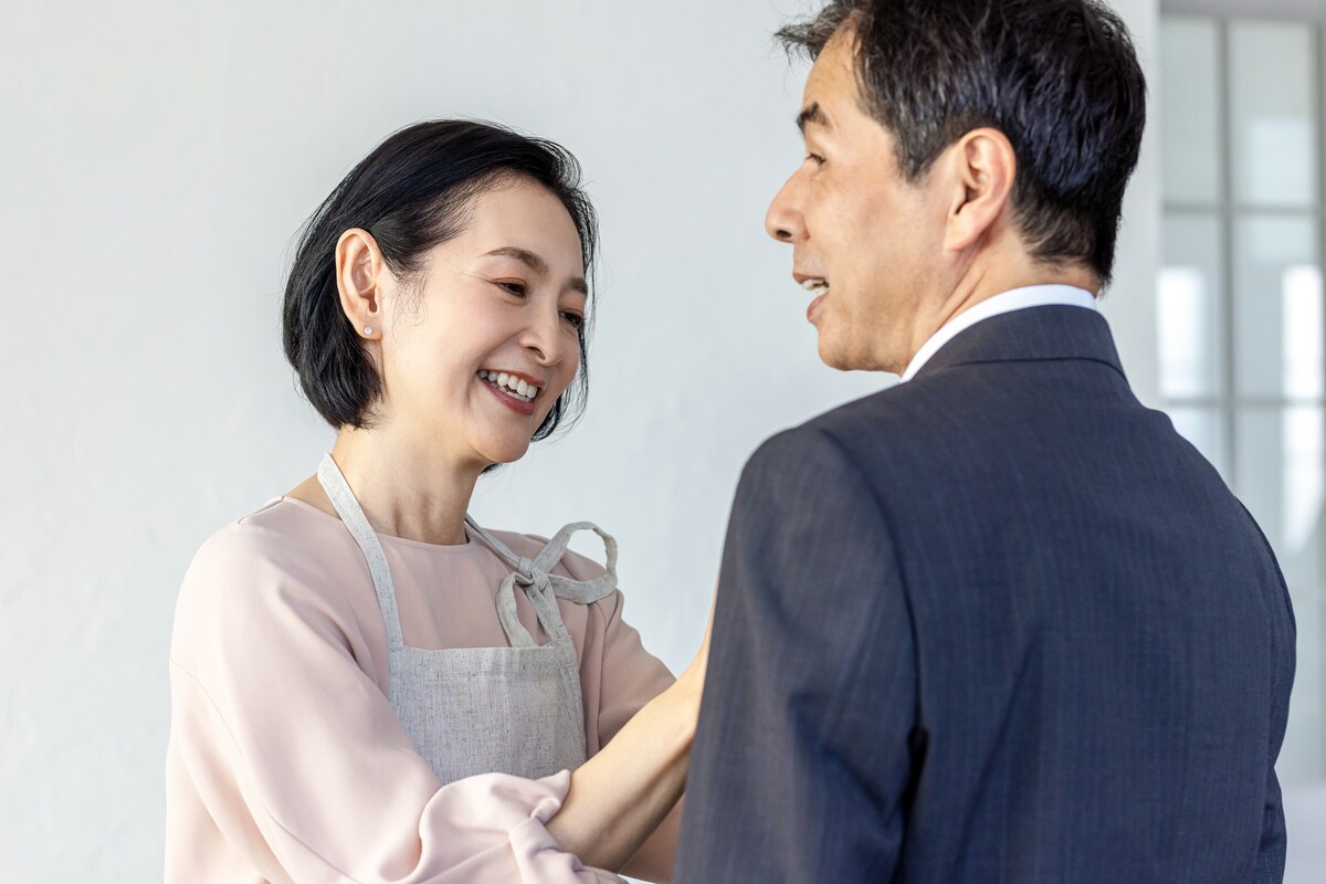 夫のネクタイを直す女性