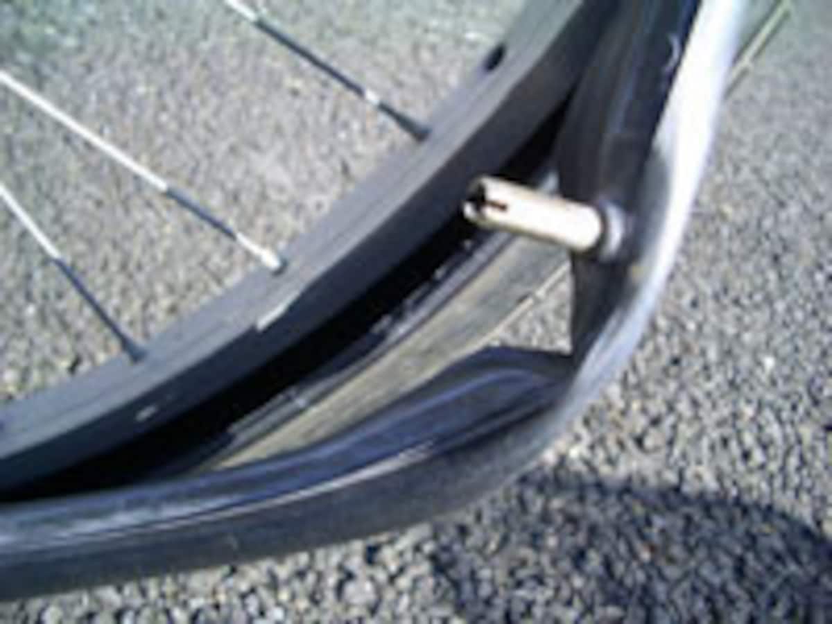 自転車のパンクの修理:中からチューブを引っ張り出し、タイヤに何か刺さっていないかを確認