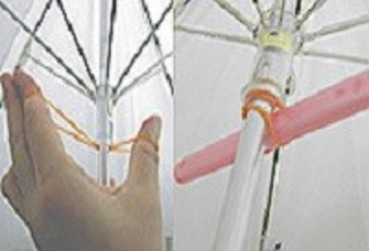 半開きで固定するのが難しい日傘は、軸の中央に輪ゴムをかけてグルグルまわし、棒状のもので固定！